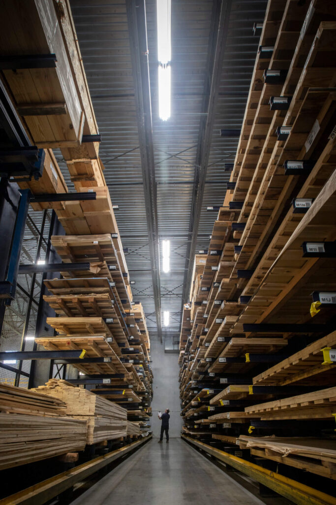 extrusions, aircraft, aerospace, metal supplier, metals an employee navigates an aisle lined with tall racks, housing a2 tool steel, a robust aerospace alloy utilized in aircraft manufacturing, under the glow of warehouse lights.