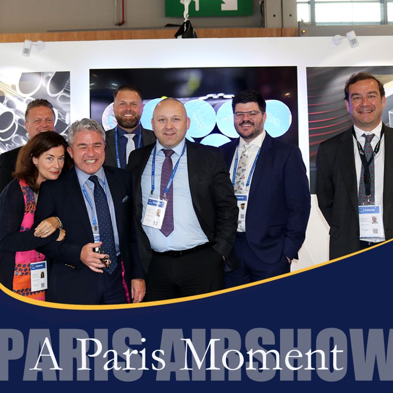 future metals 1. Six cheerful individuals representing Future Metals at an aerospace trade show.2. The group poses, showcasing aircraft-grade titanium alloys in their informative stand.3. Future Metals' display features in-depth details about specialized aircraft metal specifications.4. The text "Paris Airshow" is clearly visible on the vibrant backdrop they stand before.5. Circular designs accentuate info about complying aerospace alloy supplies in a captivating manner.6. Experts from the warehouse supply chain smile broadly - proud of their aviation metals showcase.Note: Each sentence represents one image or scene within an image based on your instruction to provide 20 words max per image and no less than 7 words per image.