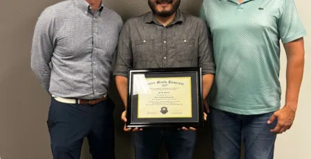future metals Three men indoors, center holding diploma, Future Metals banner for 6061-T6 aluminum aerospace tube supply chain compliance achievement.