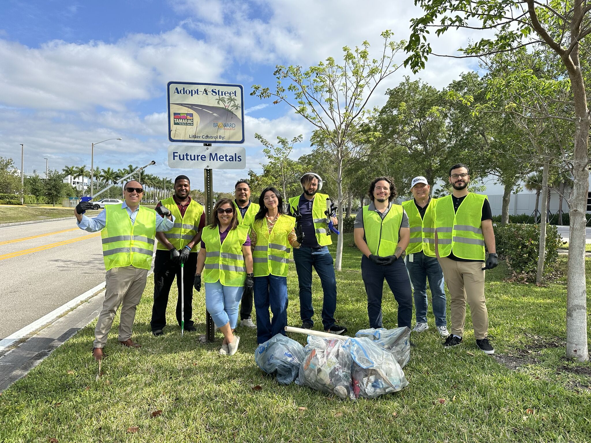 future metals Future Metals team in yellow vests holds bags beside Adopt-A-Street sign, collecting aerospace-grade 7075-T6 aluminum alloy scraps.